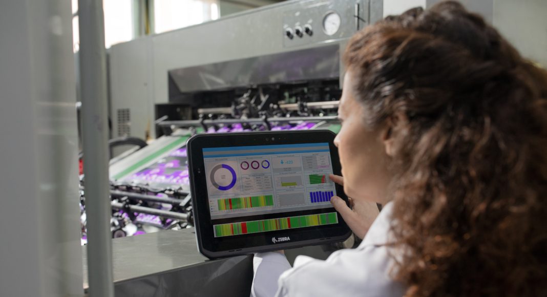 Manufacturing plant floor worker doing quality check touching sc Zebra-TPV-News-ET8x-Tai Editorial-España