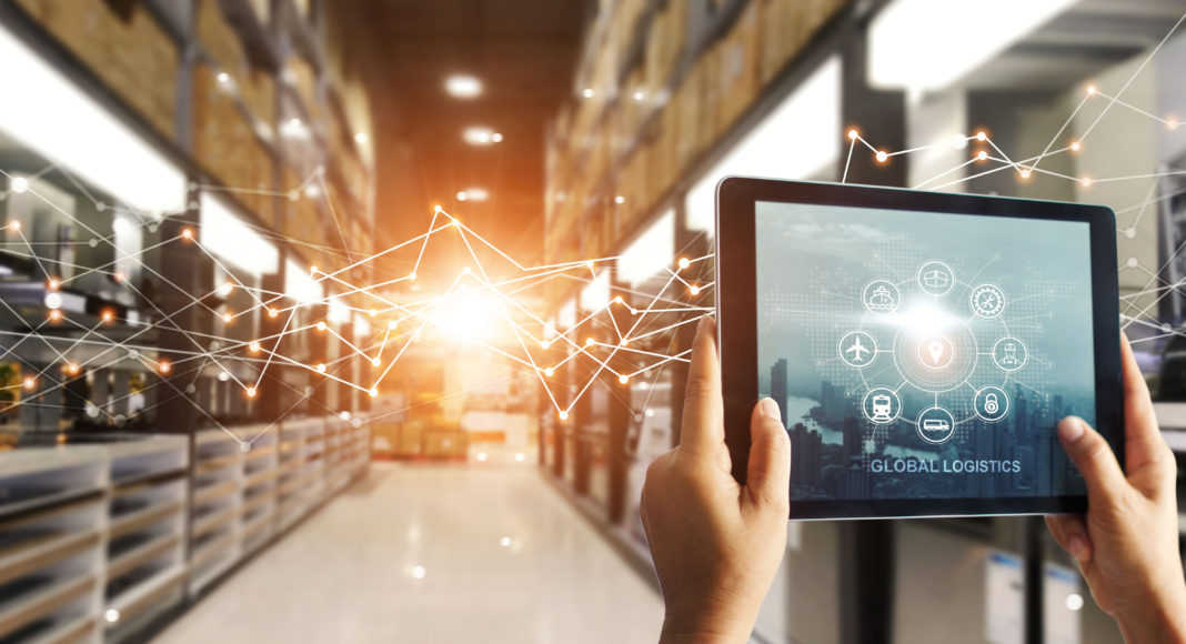 Hands,Hold,Tablet,With,Global,Logistics,Network,App,At,Distribution TeamViewer-TPVNews-Estudio-Logistics-4.0-Tai Editorial-España